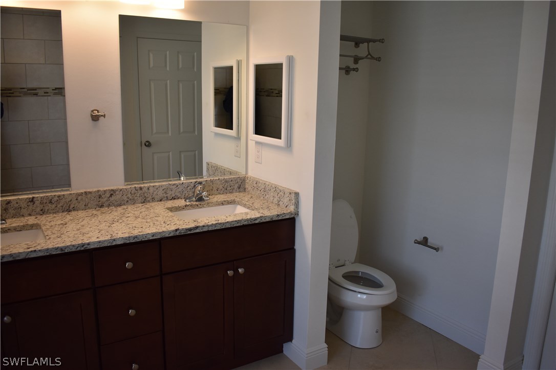 8152 Anhinga Road Fort Myers, FL 33967 - Photo 5 of 19 a bathroom with a granite countertop toilet sink and mirror