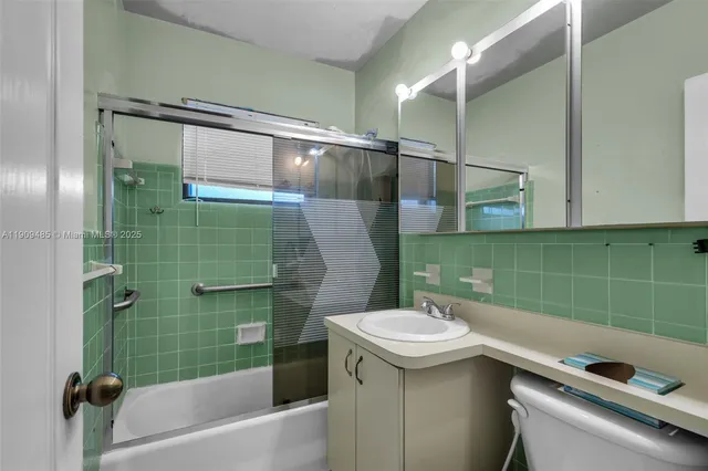 a bathroom with a sink and mirror with bathtub
