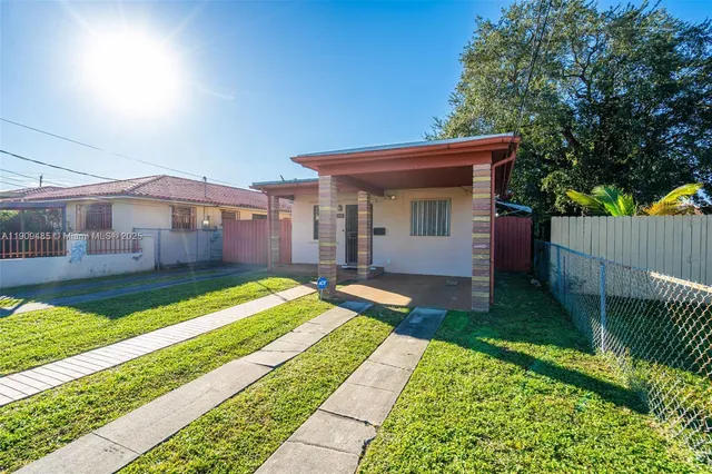 a view of house with backyard and outdoor seating
