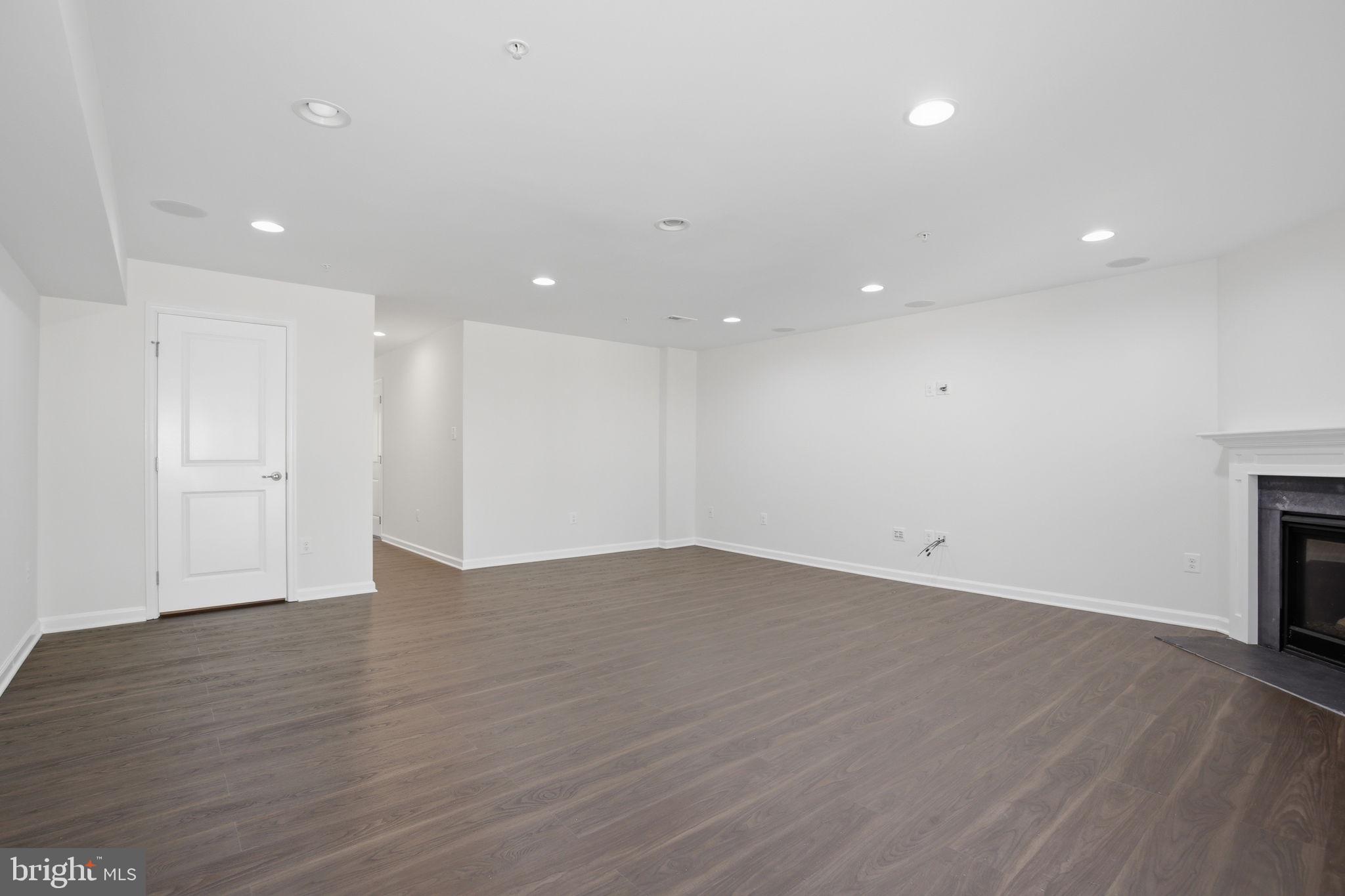 2784 Fredericksburg Road Hanover, MD 21076 - Photo 11 of 60 a view of an empty room with wooden floor fireplace and a window