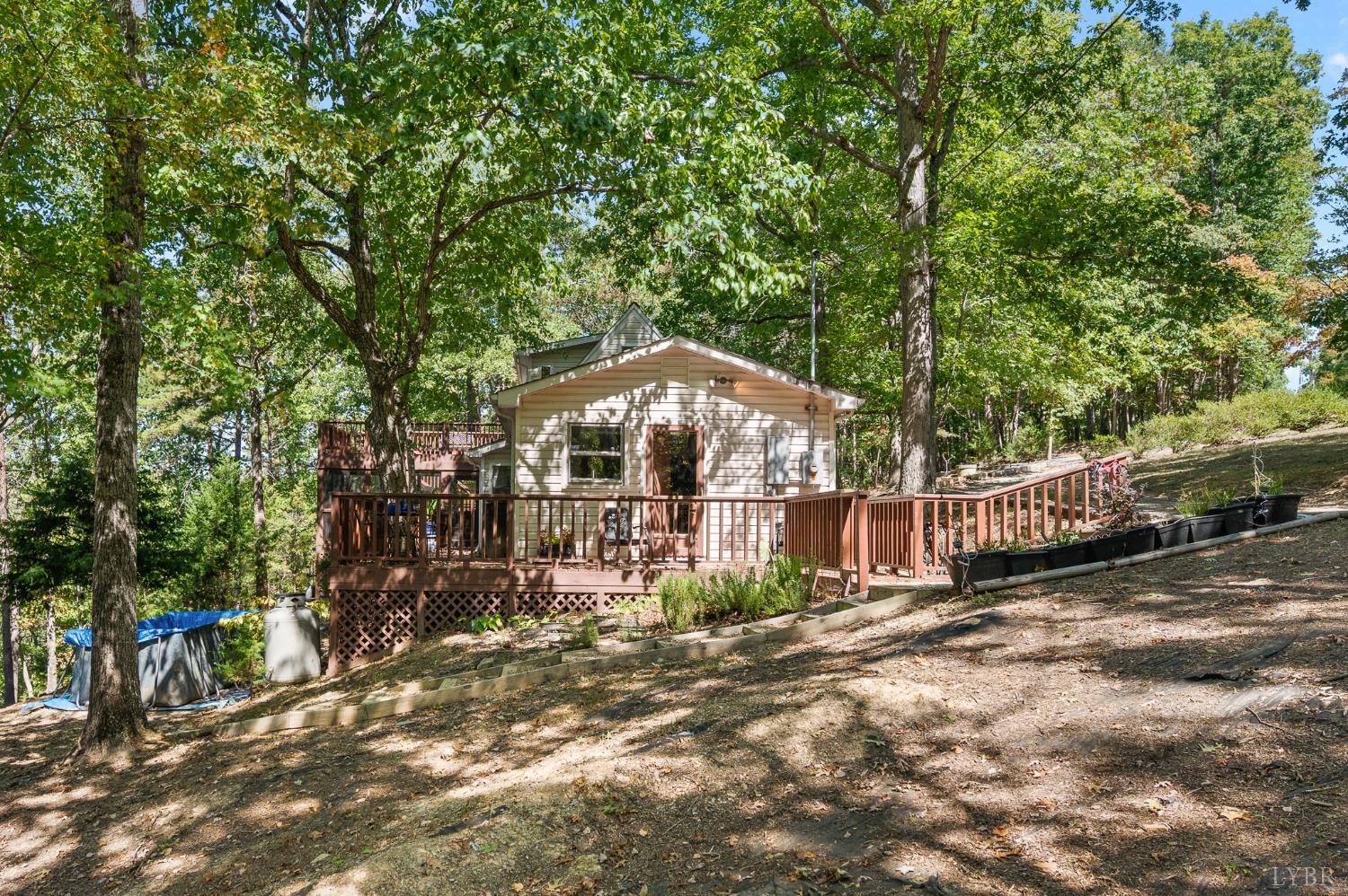 1451 Trellis Ridge Drive Lynch Station, VA 24571 - Photo 4 of 42 a backyard of a house with large trees and outdoor seating