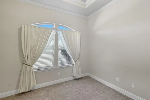 a view of a livingroom with a chandelier fan and windows