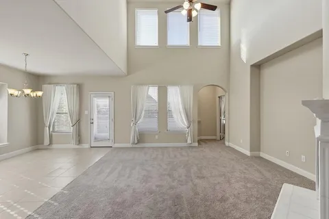 a view of an empty room with a fireplace and a window