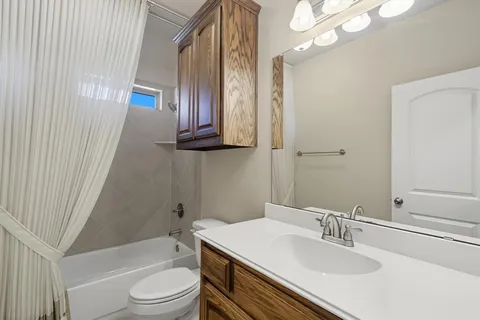 an empty room with windows and chandelier fan