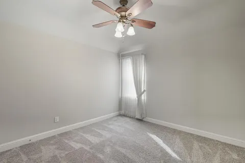 a view of a room with a window and a fan