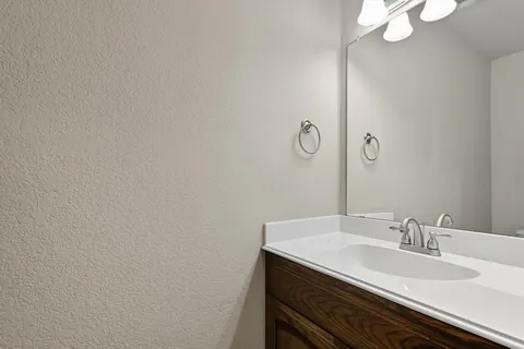 a bathroom with a granite countertop sink and a mirror