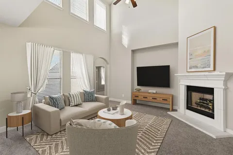 a living room with furniture a flat screen tv and a fireplace