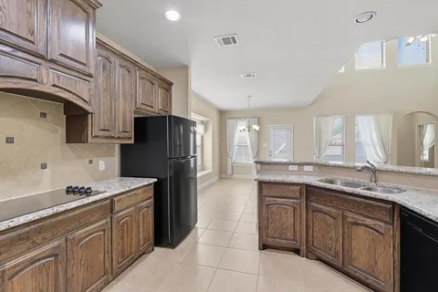 a kitchen with a sink a refrigerator and cabinets