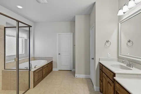 a bathroom with a tub sink and mirror