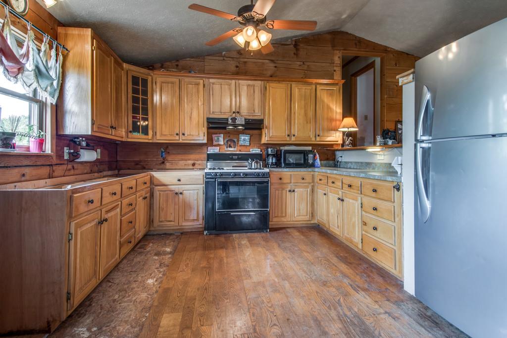 6815 Williams Road Cross Plains, TN 37049 - Photo 9 of 26 a kitchen with stainless steel appliances granite countertop a stove cabinets and wooden floor
