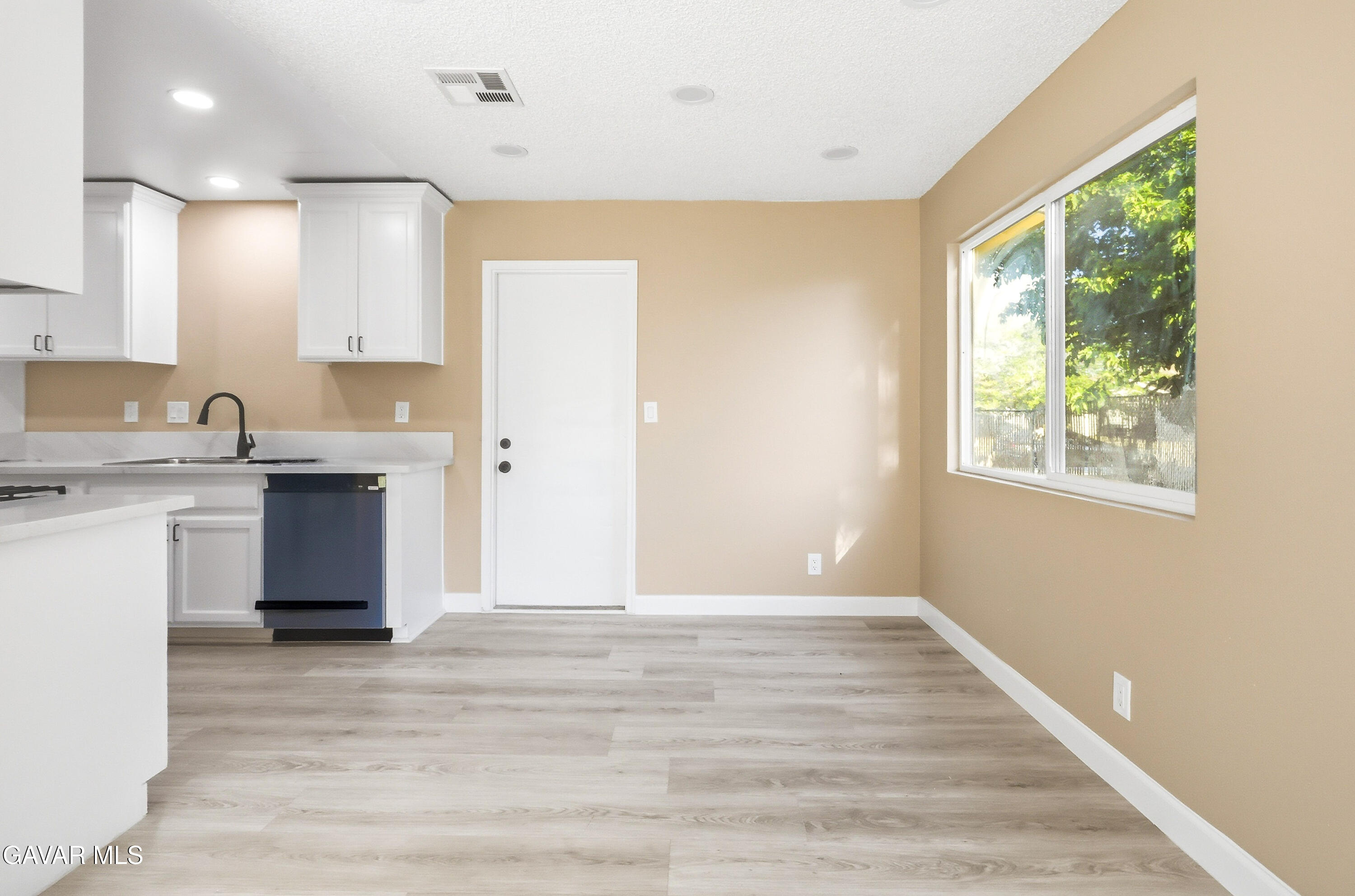 3340 West Roxbury Street Rosamond, CA 93560 - Photo 11 of 20 a view of a kitchen with wooden floor and a window