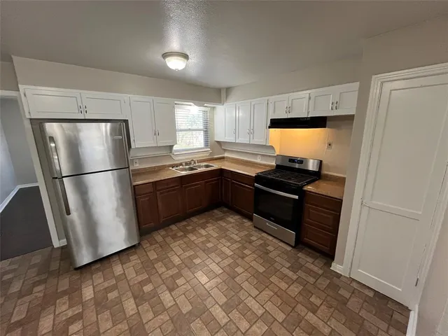 a kitchen with granite countertop a refrigerator and a sink