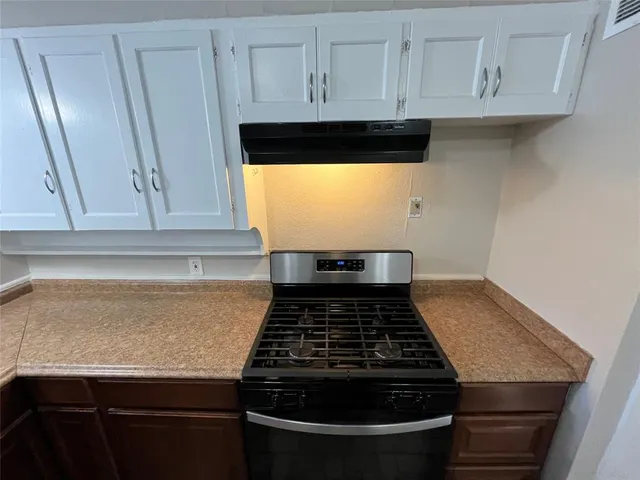a stove top oven sitting inside of a kitchen