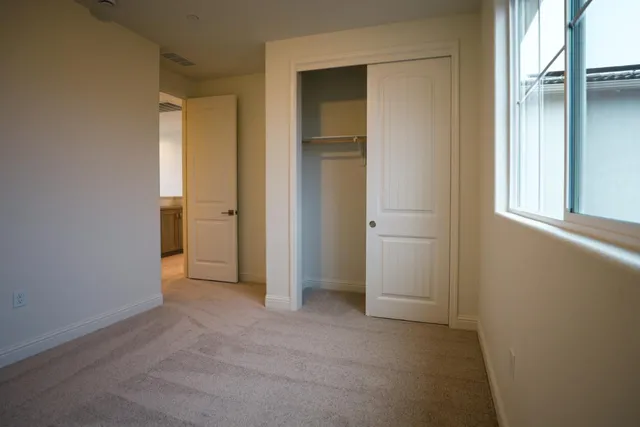 an empty room with windows and closet