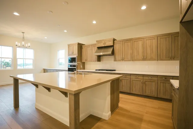 a kitchen with stainless steel appliances granite countertop a sink and a stove