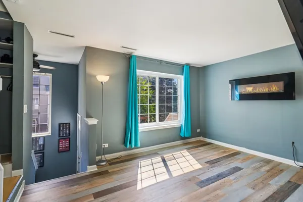 a view of a bedroom with wooden floor and a window