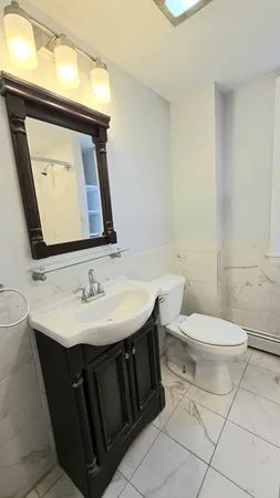 a bathroom with a sink toilet and mirror