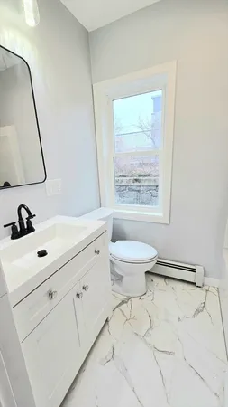 a large white kitchen with stainless steel appliances a large counter top and a stove