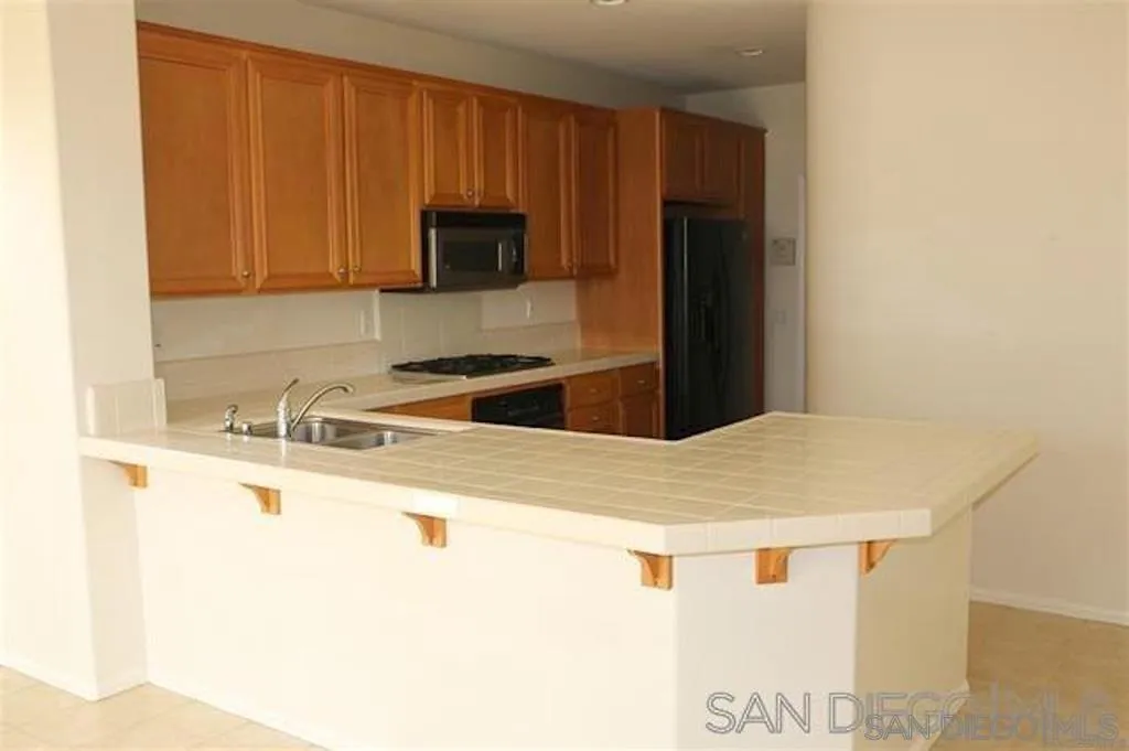 1586 Hopscotch Drive Chula Vista, CA 91915 - Photo 2 of 7 a kitchen with stainless steel appliances granite countertop a sink a stove and microwave