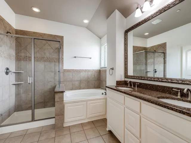 a bathroom with a sink a toilet a mirror and shower