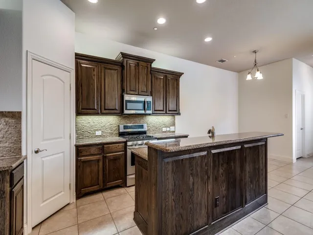 a kitchen with stainless steel appliances granite countertop a sink and stove top oven