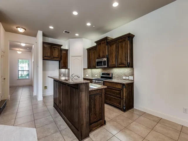 a kitchen with stainless steel appliances granite countertop a refrigerator and a stove top oven