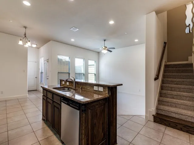 a kitchen with stainless steel appliances granite countertop a sink and a stove