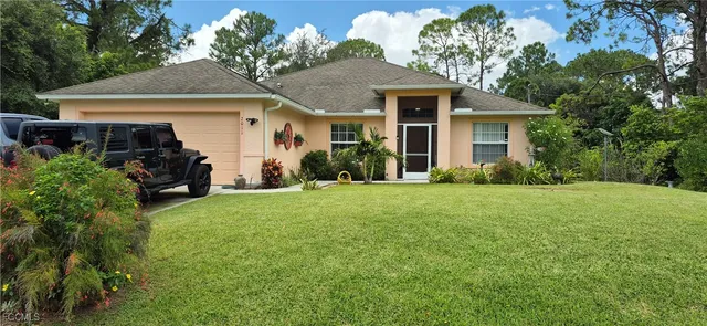 a front view of a house with a yard and potted plants
