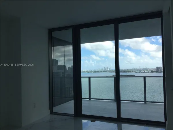a view of a glass door with a balcony from a room
