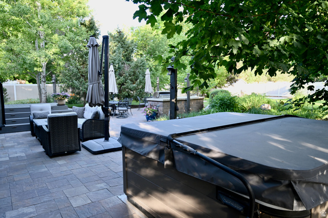 314 Brown Farm Lane Draper, UT 84020 - Photo 41 of 57 Expansive paver patio featuring a covered spa, built-in outdoor kitchen, and mature landscaping