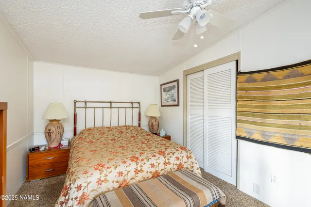 a bedroom with a large bed and a chandelier