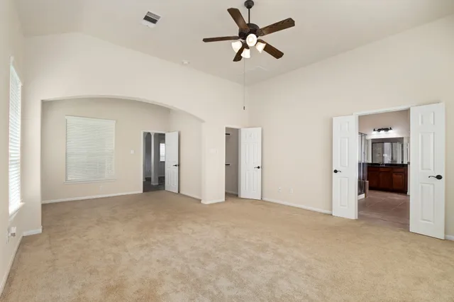 a view of a big room with closet and a ceiling fan