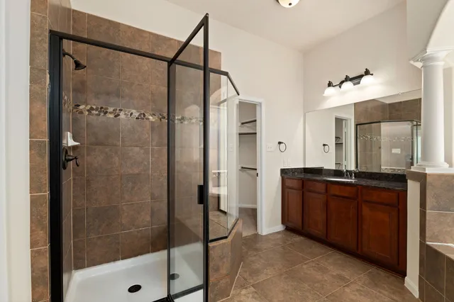 a bathroom with a glass shower door and a sink