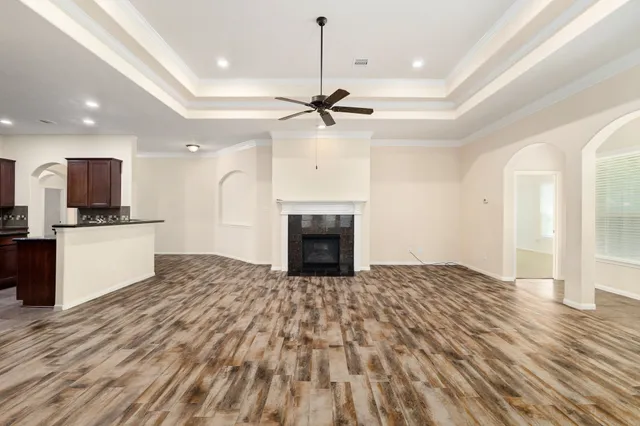 a view of a kitchen with a stove a kitchen island wooden floor and a ceiling fan