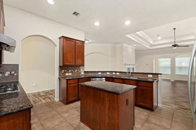 a kitchen with stainless steel appliances granite countertop a stove a sink and a microwave