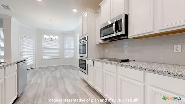 a kitchen with stainless steel appliances granite countertop a sink a stove and cabinets