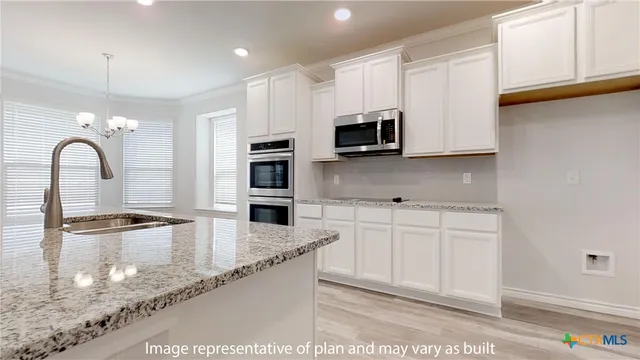a kitchen with stainless steel appliances granite countertop a sink cabinets and wooden floor