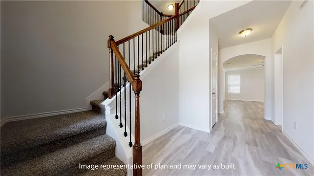 a view of hallway with wooden floor and stairs