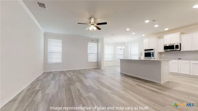 a large kitchen with stainless steel appliances kitchen island a large counter top and a wooden floors