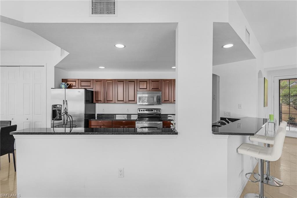 20240 Burnside Place, Unit 1603 Estero, FL 33928 - Photo 13 of 41 a kitchen with stainless steel appliances a sink and a refrigerator
