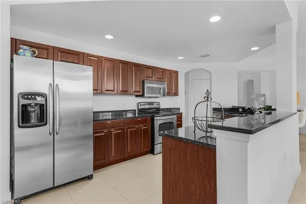 a kitchen with stainless steel appliances granite countertop a sink stove and cabinets