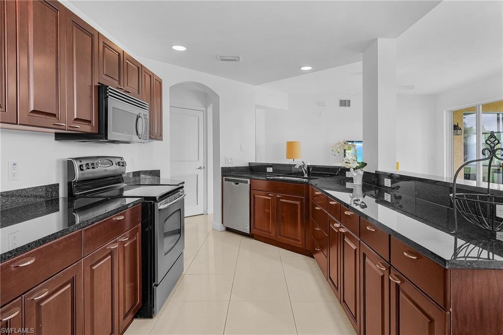 20240 Burnside Place, Unit 1603 Estero, FL 33928 - Photo 15 of 41 a kitchen with stainless steel appliances granite countertop a sink stove and cabinets