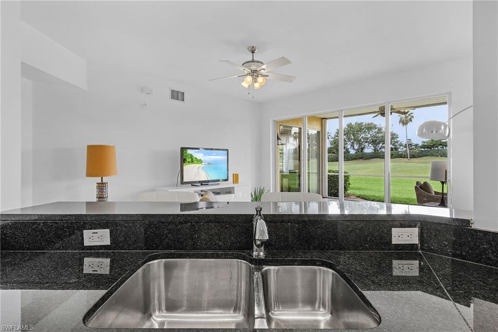 20240 Burnside Place, Unit 1603 Estero, FL 33928 - Photo 16 of 41 a kitchen with a sink and a large mirror next to a window