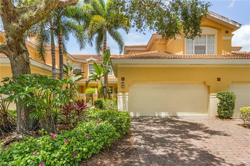 20240 Burnside Place, Unit 1603 Estero, FL 33928 - Photo 2 of 41 front view of a house with a yard and an trees