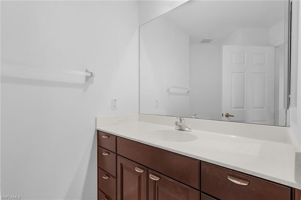 20240 Burnside Place, Unit 1603 Estero, FL 33928 - Photo 23 of 41 a bathroom with a sink and a mirror