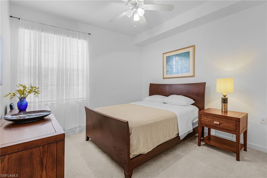 20240 Burnside Place, Unit 1603 Estero, FL 33928 - Photo 24 of 41 a bedroom with a bed and a chandelier