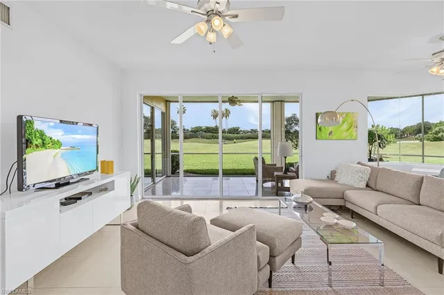 a living room with furniture a flat screen tv and a large window