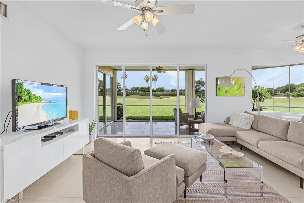 20240 Burnside Place, Unit 1603 Estero, FL 33928 - Photo 7 of 41 a living room with furniture a flat screen tv and a large window