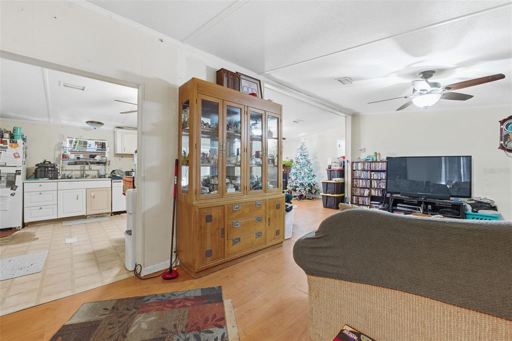 13050 Sun Road Brooksville, FL 34613 - Photo 12 of 47 a living room with furniture a flat screen tv and kitchen view