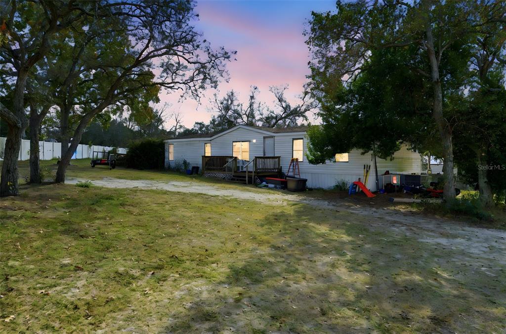 13050 Sun Road Brooksville, FL 34613 - Photo 3 of 47 a front view of a house with a yard and trees